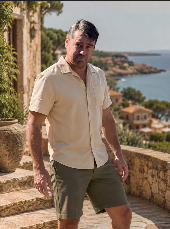 An olive colourway of the Hero Hybrid Short, worn on a coastal villa terrace.